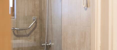 A modern bathroom with a glass-enclosed shower, a toilet, and a vanity with a wooden cabinet.