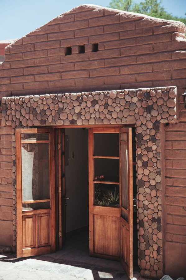 A rustic building with a wooden door and a stone wall.