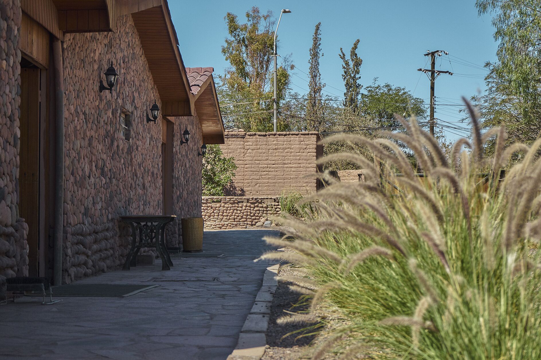 A stone building with a wooden door and a bench outside.