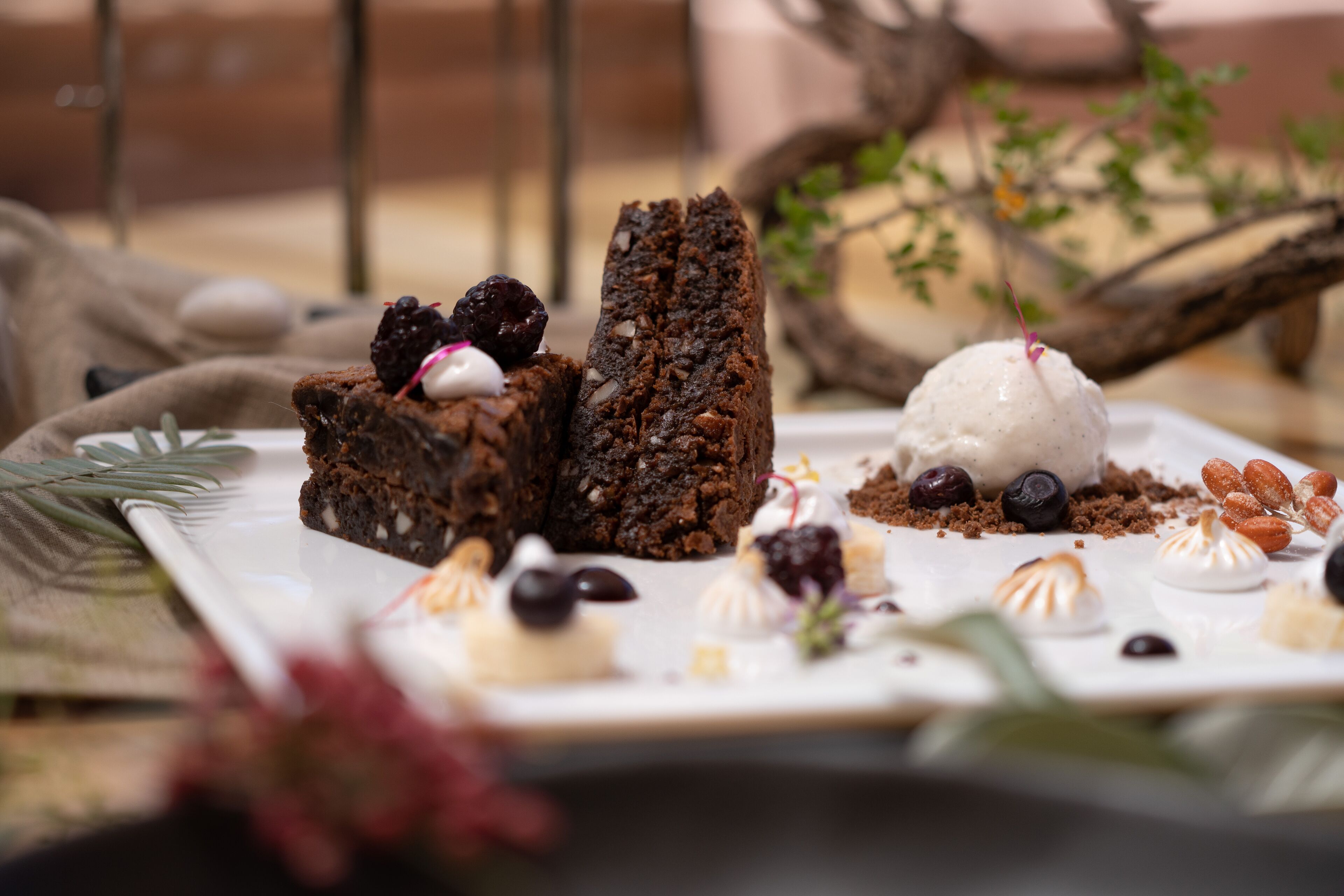 A dessert plate with various sweets and a chocolate cake.