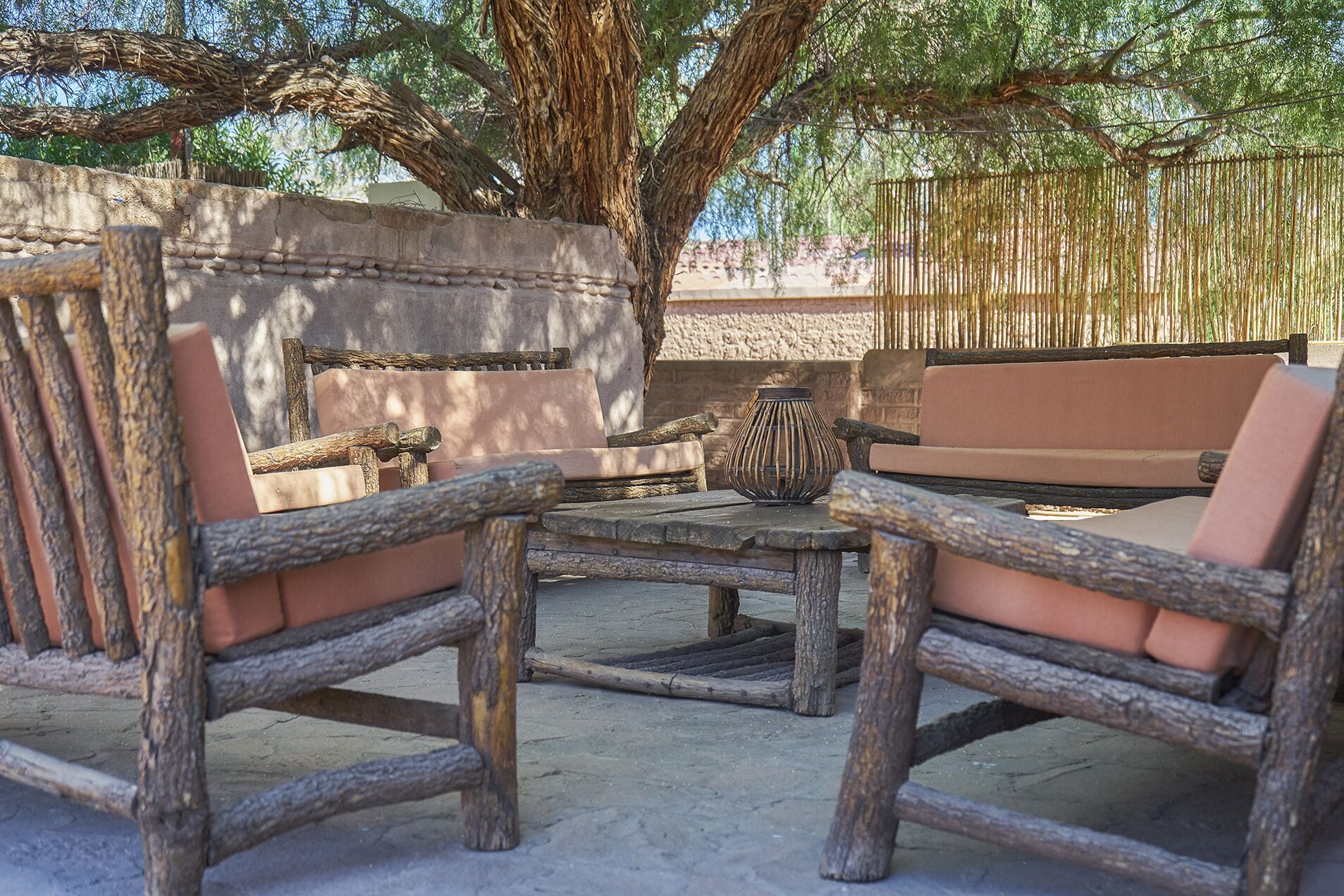 Un espace extérieur aménagé avec des meubles en bois rustique et une table en pierre.