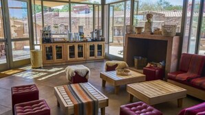 A spacious living area with large windows, a fireplace, and a variety of seating options including sofas and ottomans.