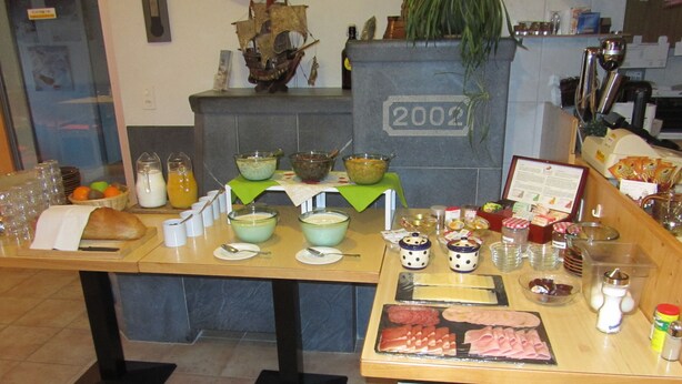 A buffet setup with various food items and beverages. - Pension Egg (Hospental)