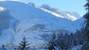 A snow-covered mountain landscape with a ski resort in the valley. - Pension Egg (Hospental)