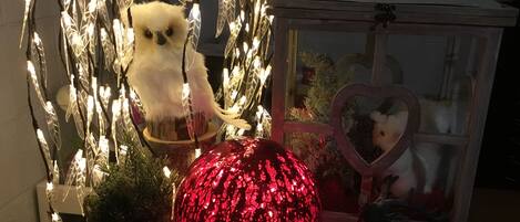 Una exhibición decorativa con un peluche, un adorno con forma de corazón y un objeto esférico rojo.