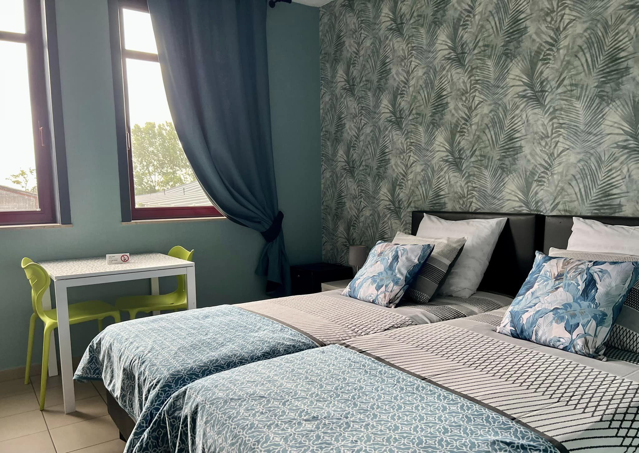 Une chambre avec deux lits, un bureau et une chaise.