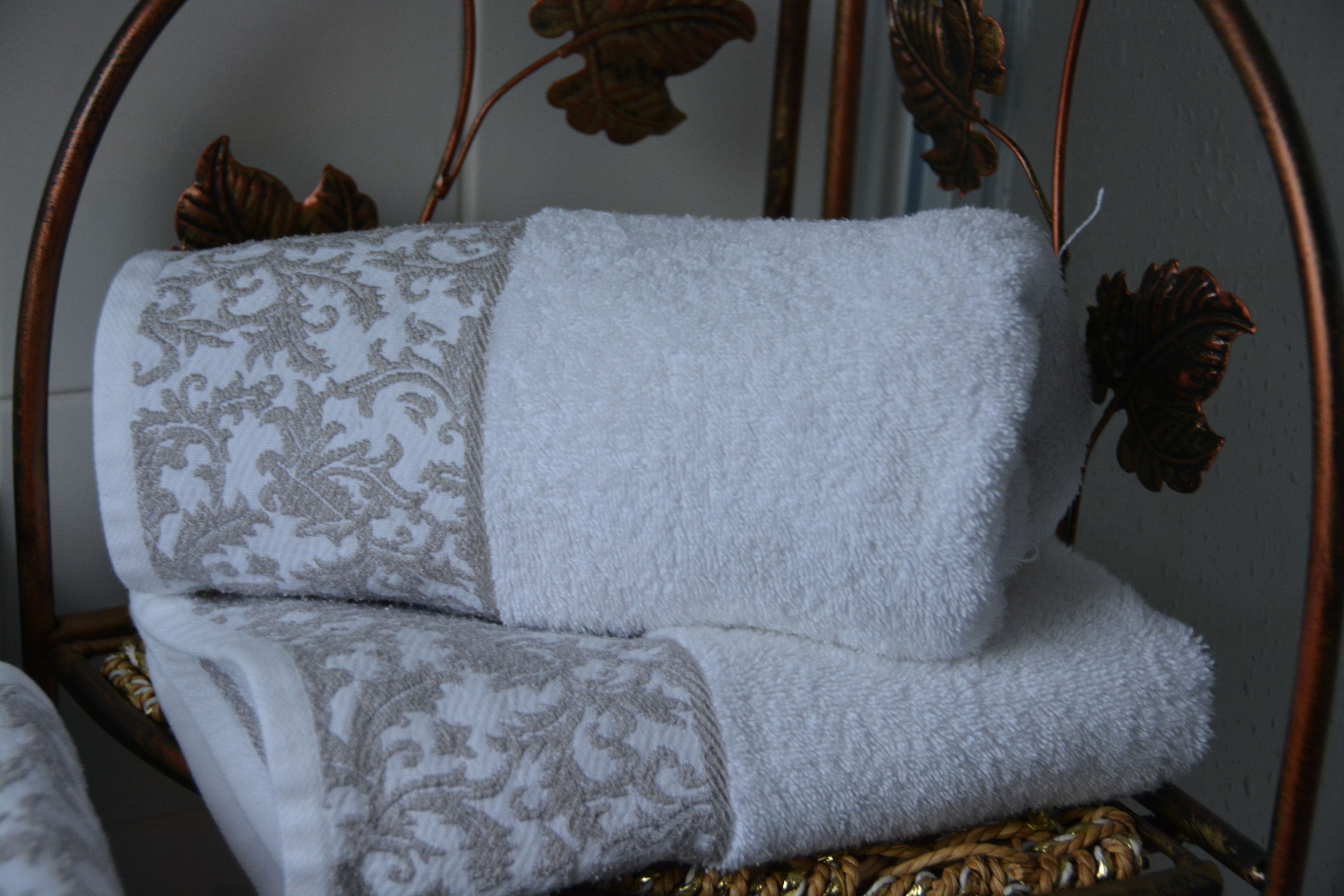 Una cama con una colcha estampada y otra manta blanca lisa.