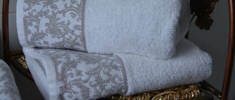 Una cama con una colcha estampada y otra manta blanca lisa.