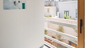 Un intérieur moderne avec un balcon donnant sur un quartier résidentiel.