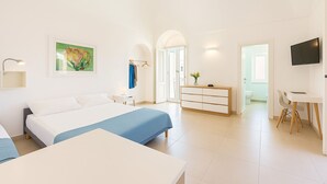 Une chambre d’hôtel moderne, dotée d’un grand lit, d’un bureau et d’une télévision.