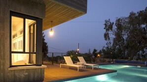 A modern pool area with two lounge chairs and a wooden deck. - Pnai - Villa in the Galilee (Rosh Pinna)