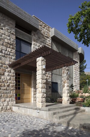 A stone building with a wooden door and a covered entrance. - Pnai - Villa in the Galilee (Rosh Pinna)