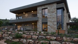 A modern two-story house with a stone facade, large windows, and a balcony. - Pnai - Villa in the Galilee (Rosh Pinna)