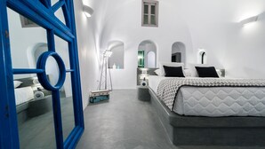 Un dormitorio moderno con una cama grande, un espejo de marco azul y una ventana pequeña.