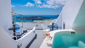 Un balcón soleado con piscina, dos mesas y sillas, y una vista despejada del mar y islas a lo lejos.