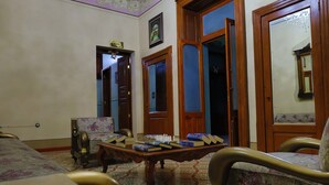 A room with a bed, a wooden table with books, a chair, and a door with a mirror. - Azcami Boutique Hotel (Puebla)