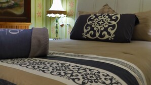 A hotel room with a bed, a nightstand with a lamp, and a painting on the wall. - Azcami Boutique Hotel (Puebla)