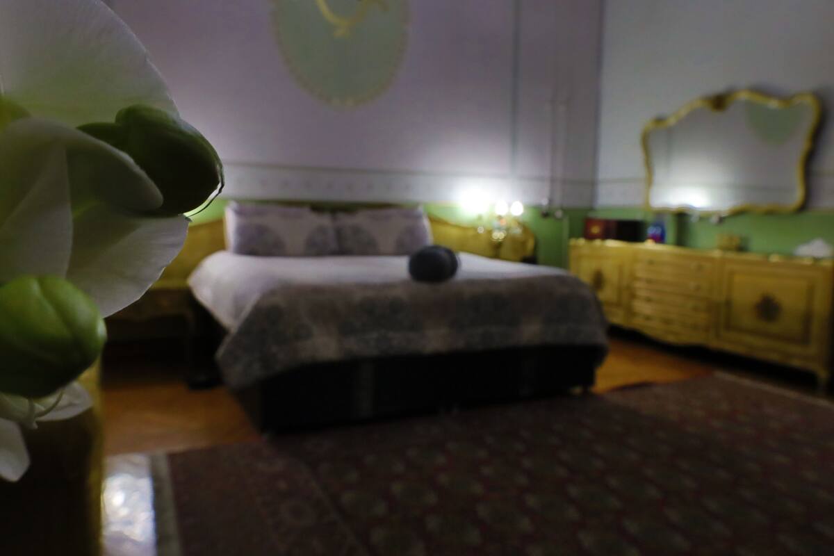 A bedroom with a bed, a dresser, and a mirror.