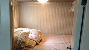 A small, narrow room with a single bed, a ceiling light, and a door. - Spits-Lucie B&B (Izegem)