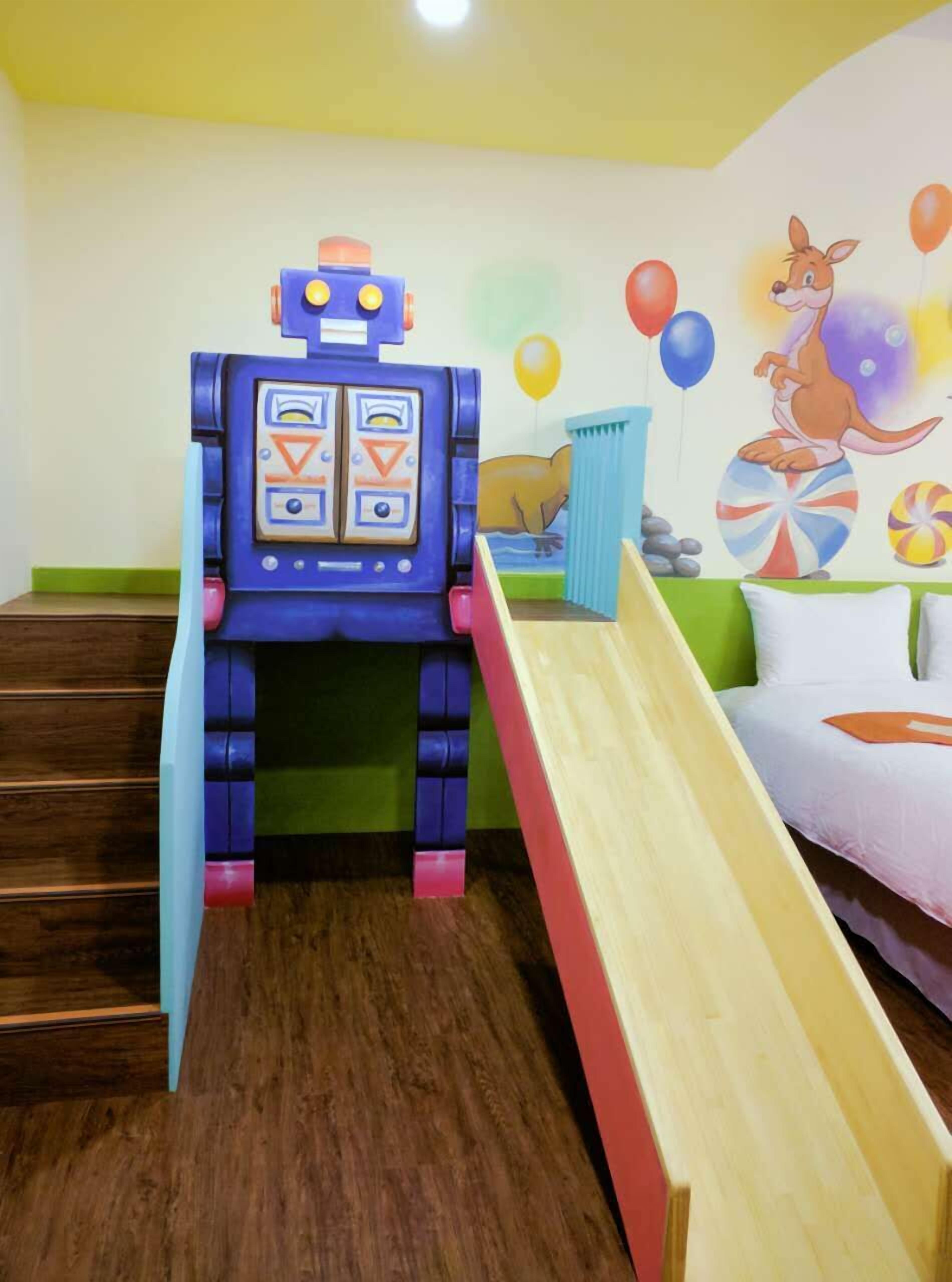 Legeområde for børn med rutchebane og en legestruktur med robot-tema.