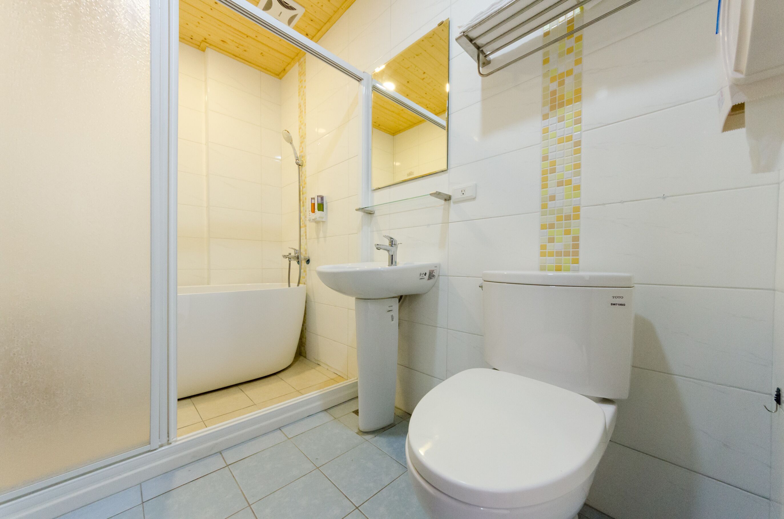 A bathroom with a bathtub, sink, toilet, and a shower area.