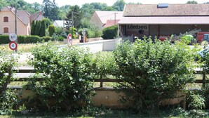 Un bâtiment rural avec une enseigne indiquant « Lordson » et un tracteur rouge garé à l’extérieur.