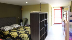 Une chambre à coucher comprenant un lit, une armoire et une porte donnant sur une autre pièce.
