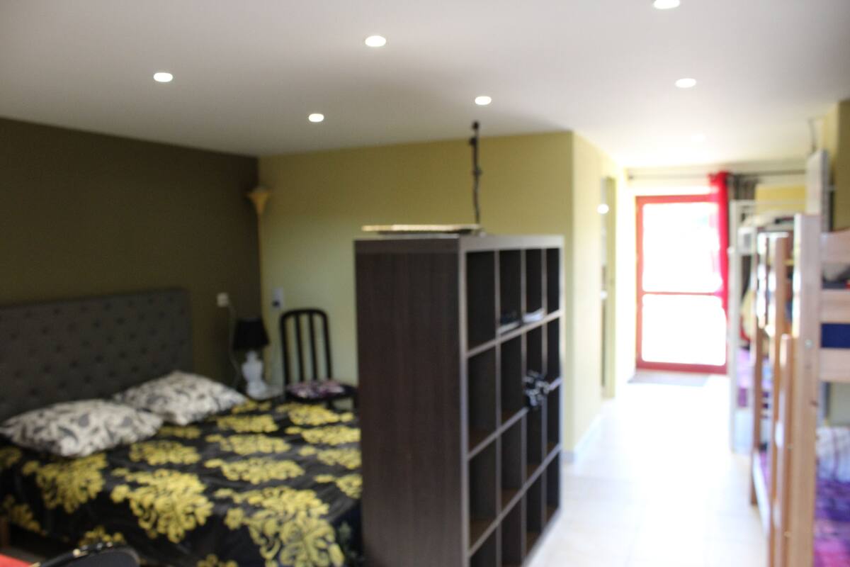 A bedroom with a bed, a wardrobe, and a door leading to another room.