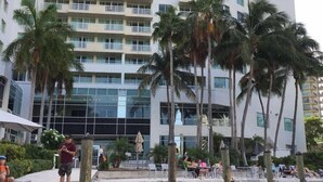 A multi-story hotel with balconies, palm trees, and a waterfront view. - Gallery One Private Condos (Fort Lauderdale)