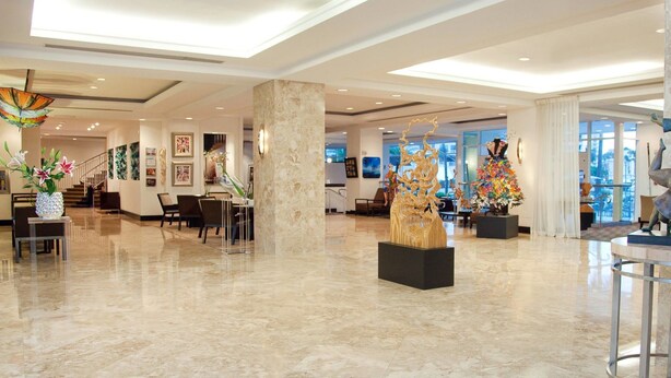 A spacious lobby with marble flooring, modern furniture, and various art installations. - Gallery One Private Condos (Fort Lauderdale)