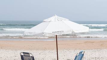 Na praia, barracas de praia de cortesia, espreguiçadeiras, guarda-sóis