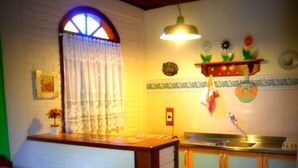 Cozinha com janela, pia e armário.
