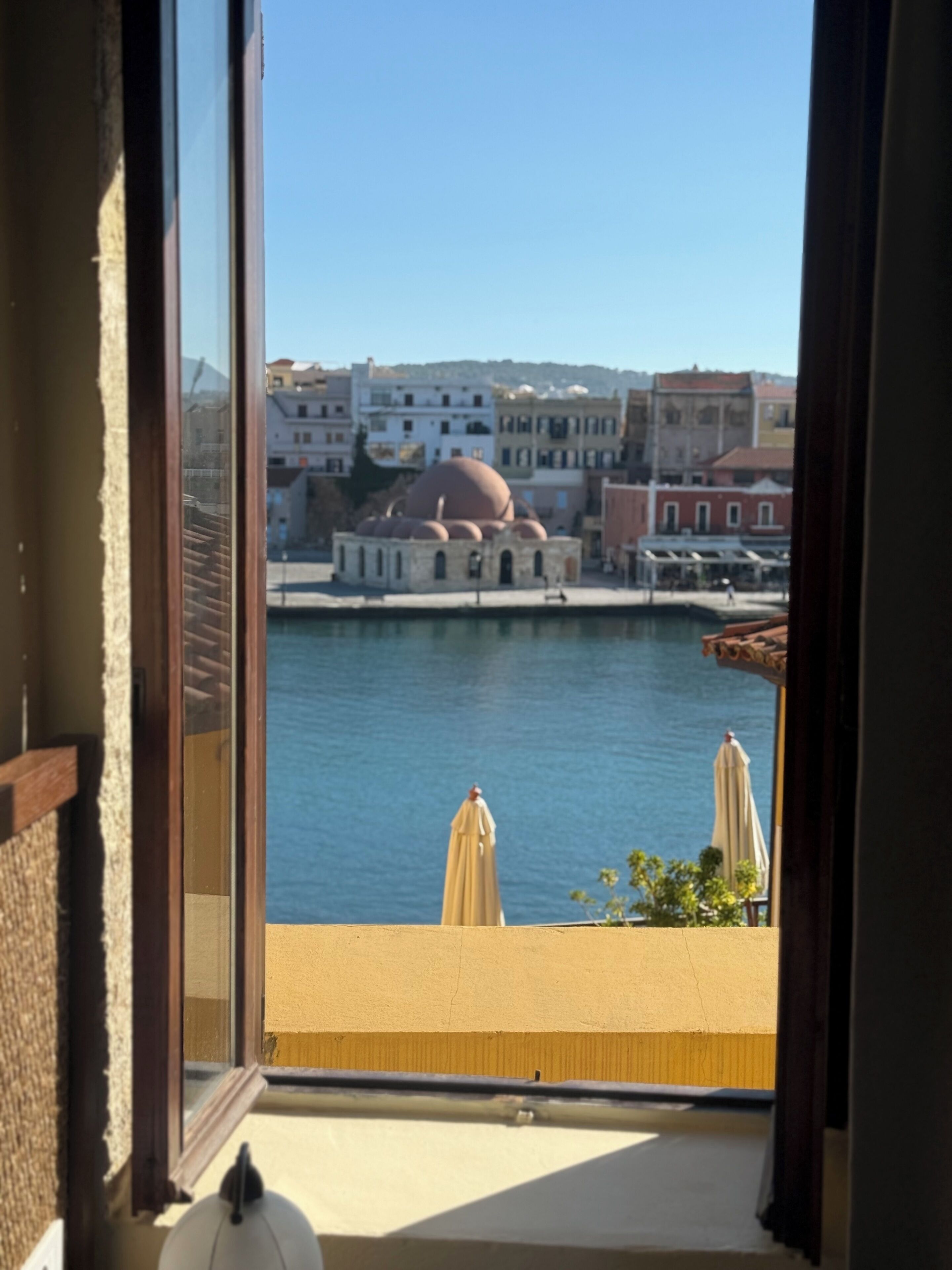 A balcony with a view of a body of water, buildings, and a dome structure.