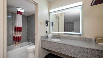 Et badeværelse med badekar, toilet og håndvask.