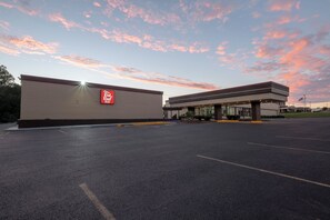 A parking lot with a building that has a sign reading 'Real Room Inn'.