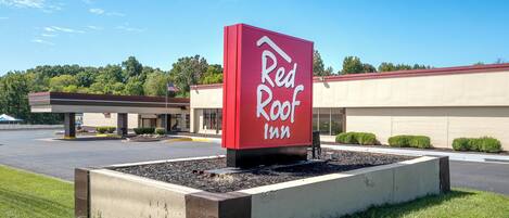 Un letrero de Red Roof Inn con vista despejada del edificio al fondo.