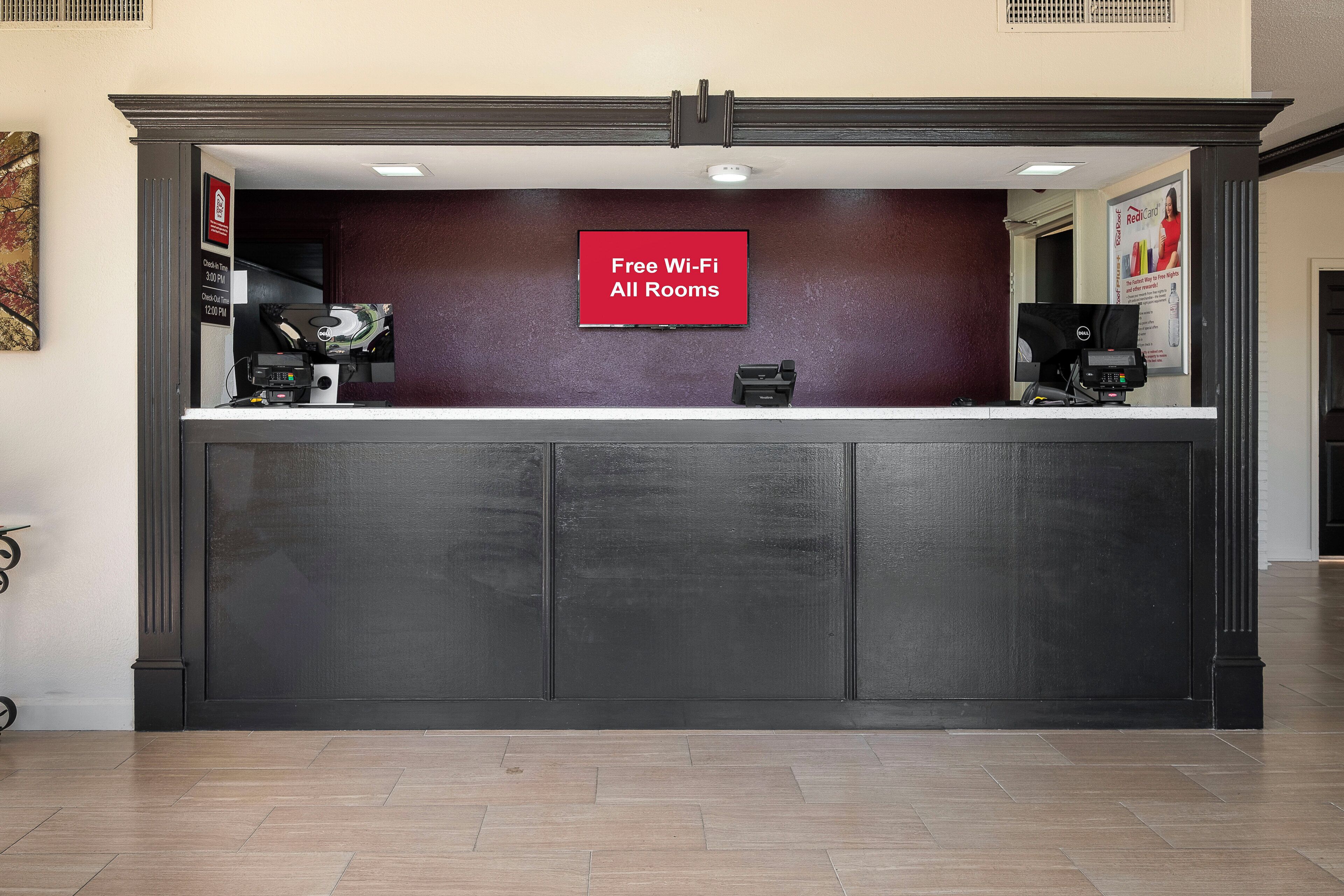 A reception desk with a sign indicating free Wi-Fi in all rooms.