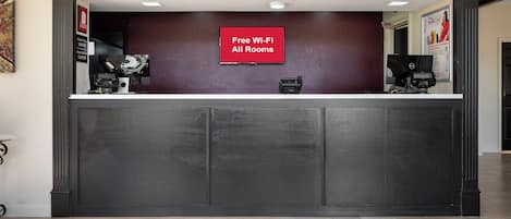 A reception desk with a sign indicating free Wi-Fi in all rooms.