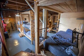 A loft-style bedroom with bunk beds, a staircase, and a visible bathroom. - PodShare DTLA Arts District - Hostel (Los Angeles)