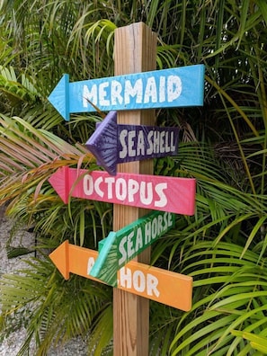 A wooden signpost with directional arrows pointing to different sea creature names.
