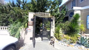 Un cancello con un cartello che riporta "Riverlodge Backpackers" e un segnale "Reception" che indica che l'accesso è riservato.