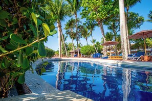 A clear blue pool surrounded by palm trees and lounge chairs. - Hotel Quinta do Porto (Porto Seguro)