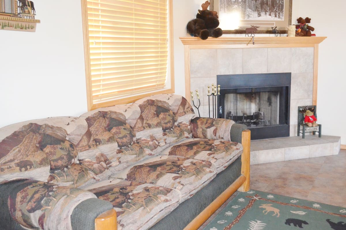 A living room with a sofa, fireplace, and a framed picture above it.