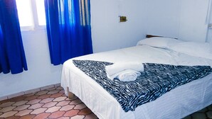 A single bed with a zebra-patterned blanket, white pillows, and a white duvet. - El Dorado Residencial (Lima)