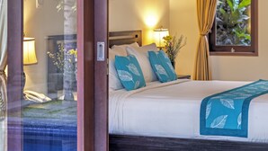 A hotel room with a bed, a bedside lamp, a phone, and a window with curtains. - Villa Kedis (Canggu)