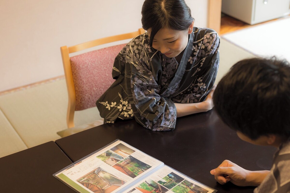A person sitting at a table with a booklet.