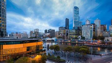 A cityscape with modern buildings, a river, and a bridge.