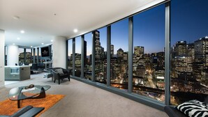 Una sala moderna con vistas a la ciudad, una zona de cocina y un amplio ventanal.
