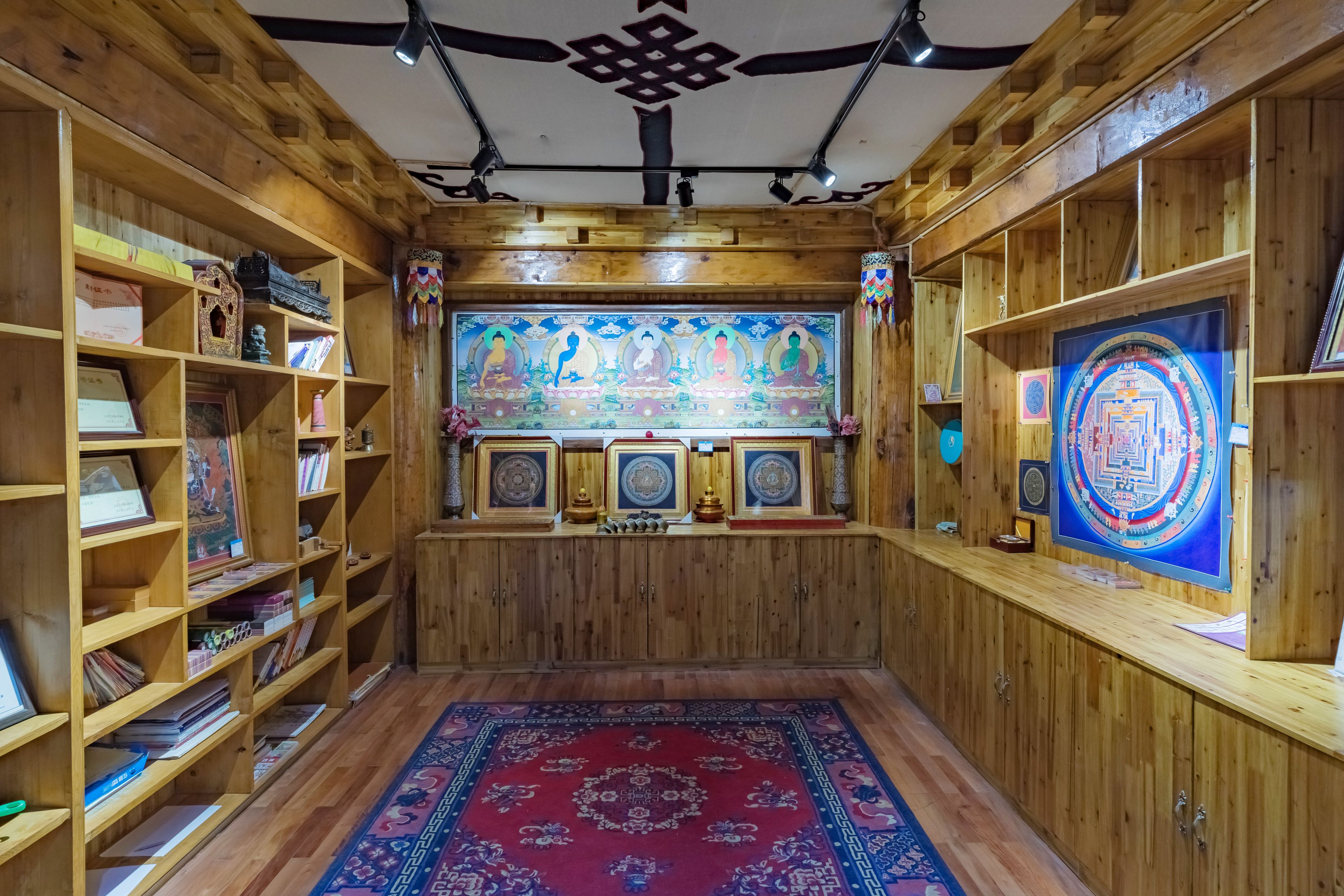A room with wooden walls and shelves filled with books and framed items.