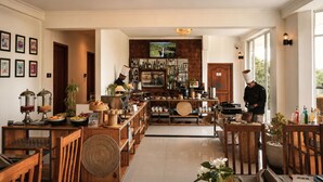 A spacious hotel lobby with a bar area, wooden furniture, and a view of the outdoors. - Onrock Boutique Hotel (Ella)